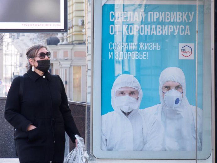 Una mujer con mascarilla pasea por Moscú
