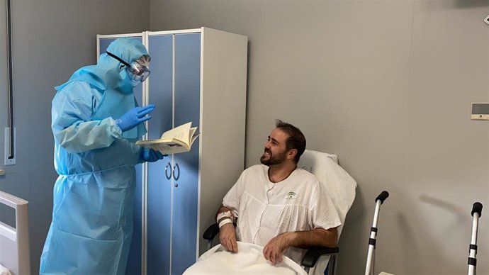 Un voluntario con un paciente con COVID en aislamiento en el Hospital Regional de Málaga