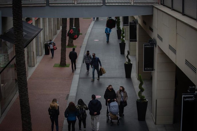Archivo - Varias personas realizan compras en un centro comercial, en una imagen de archivo