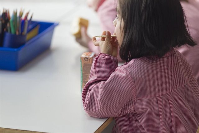 Archivo - Niña desayunando en un colegio.