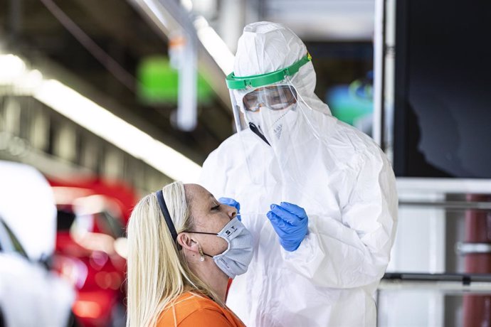 Un sanitario realiza un test de antígenos a una trabajadora de Seat al lado de la línea de producción.