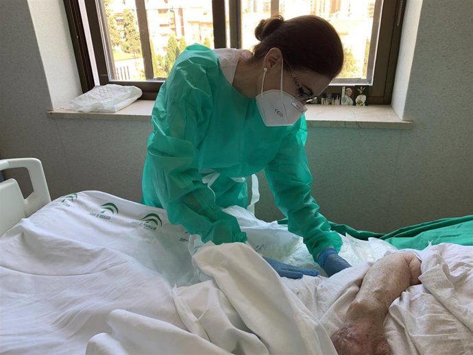 Una profesional sanitaria atiende a una persona ingresada en el hospital en Málaga