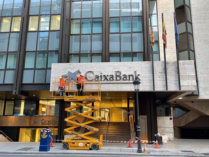 Operaris colloquen el logo de CaixaBank en l'edifici que albergava la seu de Bankia a Valncia