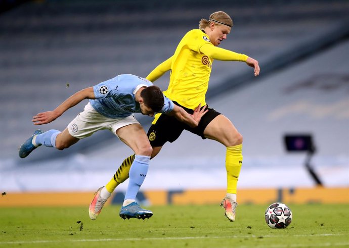 06 April 2021, United Kingdom, Manchester: Manchester City's Ruben Dias (L) and Borussia Dortmund's Erling Haaland (R) battle for the ball during the UEFA Champions League quarter-final first leg soccer match between Manchester City and Borussia Dortmun