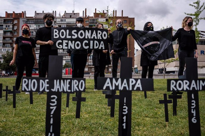 02 April 2021, Spain, Madrid: Group of Brazilian citizens hold Genocidal Bolsonaro banners at the Madrid Rio park during a commemorative act to remember the hundreds of deaths of people from the Coronavirus (Covid-19) pandemic in Brazil. Photo: Diego Ra