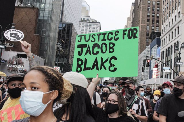 Archivo - 24 August 2020, US, New York: A protester holds a sign during a march at Time square following the shooting of Jacob Blake, an African-American man, by a white police officer. Photo: John Marshall Mantel/ZUMA Wire/dpa