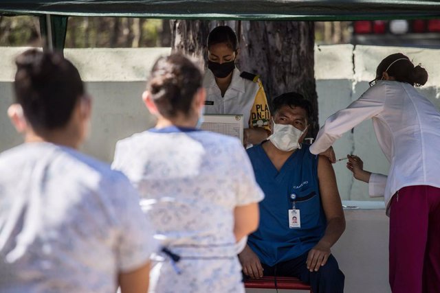 Archivo - Un trabajador sanitario recibe una dosis de la vacuna contra el coronavirus en el Hospital Militar de Ciudad de México.