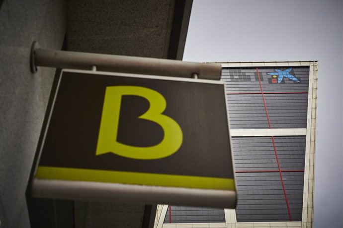 Un cartel con el símbolo de Bankia delante del logo de Caixabank tras su sustitución por el de Bankia en las torres Kio, en Madrid (España), a 27 de marzo de 2021. Los edificios más emblemáticos cambiarán su logo este fin de semana y durante los próximo