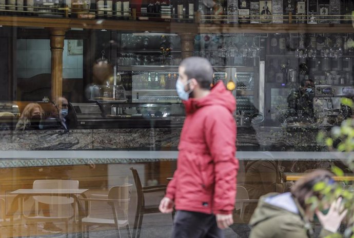 Archivo - Un hombre camina frente a un bar el primer día de la apertura de la hostelería en Valencia