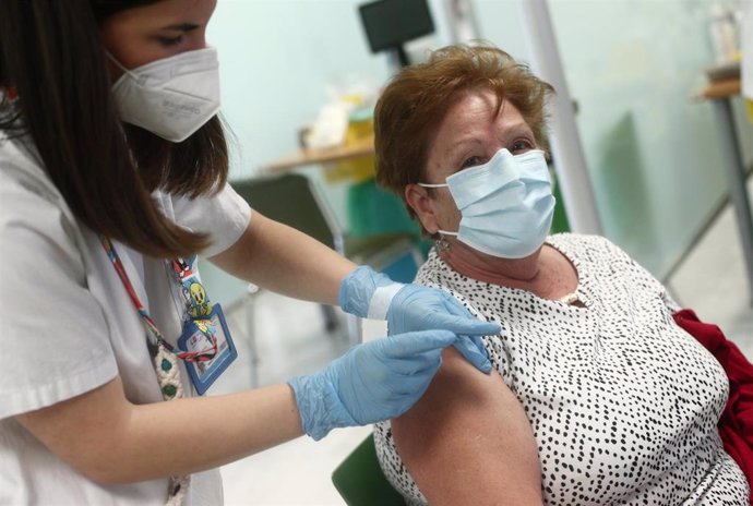 Una sanitaria inocula la primera dosis de la vacuna Pzifer a una anciana, en el Hospital Universitario de La Paz