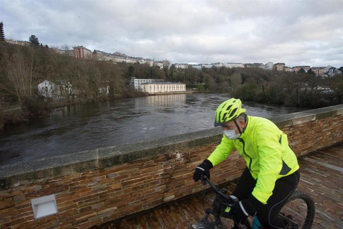 Archivo - Un ciclista cruza el Puente Romano, por el que pasa el Río Miño, en Lugo, Galicia, (España), a 27 de enero de 2021. Como consecuencia de las borrascas encadenadas que han descargado copiosas precipitaciones en los últimos días sobre la provinc