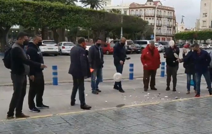 Hosteleros de Melilla rompiendo platos en la puerta del Palacio de la Asamblea