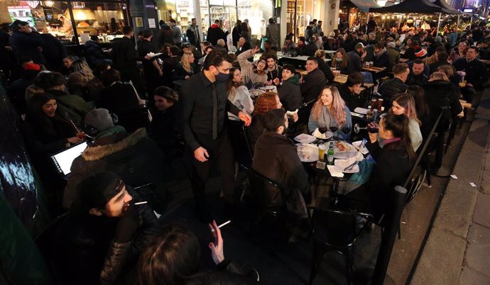 12 April 2021, United Kingdom, London: People crowd at the outdoor areas of pubs in the Soho district, as Corona lockdown restriction eased in London. Photo: Jonathan Brady/PA Wire/dpa