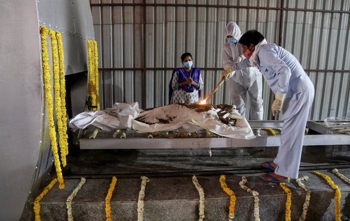 13 April 2021, India, New Delhi: Relatives of a person died of COVID-19 diseas, perform rituals on his bodz before the cremation in a CNG furnace at Nigambodh Ghat crematorium in New Delhi. Photo: Naveen Sharma/SOPA Images via ZUMA Wire/dpa