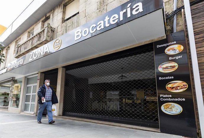 Un hombre camina frente a una cafetería cerrada en O Grove, el día en que entra en vigor el cierre perimetral del municipio, a 8 de abril de 2021, en Pontevedra, Galicia, (España).  