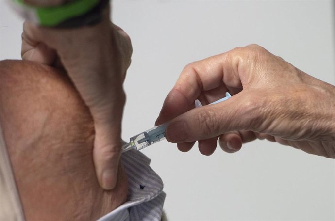 Una trabajadora sanitaria administra la primera dosis de la vacuna AstraZeneca contra el Covid-19 a una persona en el Wizink Center, a 9 de abril de 2021, en Madrid, (España). 