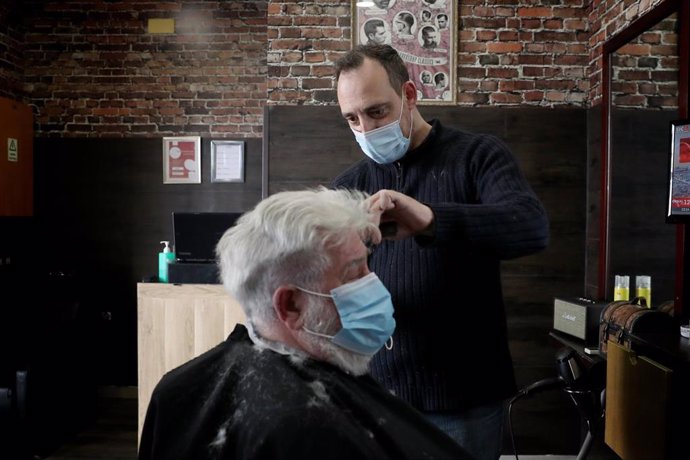 Un hombre se corta el pelo en una barbería lisboeta aprovechan la reapertura de negocios prevista en el plan de desescalada del Gobierno.