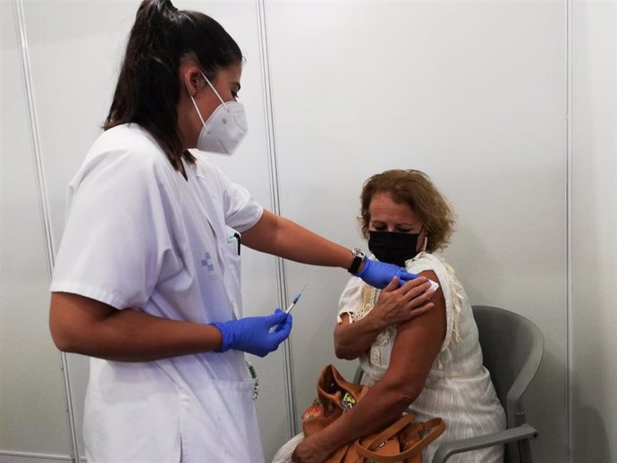 Una mujer se vacuna contra la covid-19 en el centro de vacunación masiva de Infecar
