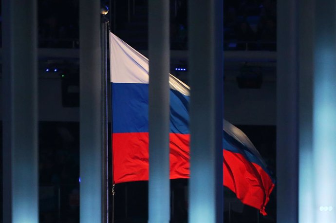 Archivo - FILED - 07 March 2014, Russia, Sochi: The Russian flag is pictured behind a fence during the Opening ceremony of the 2014 Winter Paralympics at the Fisht Olympic stadium in Sochi.  Russia is facing a four-year sporting ban  in connection with 