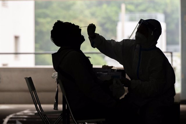 Archivo - 12 December 2020, China, Hong kong: A health worker takes a swab sample from a man at a Covid-19 testing centre in Hong Kong. Photo: Geovien So/SOPA Images via ZUMA Wire/dpa