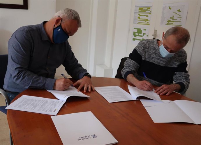 El conseller de Promoción Económica y Desarrollo Local, Jaume Alzamora, firmando el convenio con el presidente de la Asociación Mercado Social Islas Baleares, Jordi López.