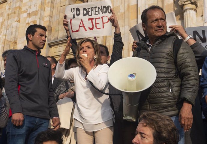 Archivo - 13 March 2019, Colombia, Bogota: Protesters hold signs and shout slogans during a protest against Colombian President Ivan Duque's announcement that he was objecting to a number of articles in the legislation regulating the Special Jurisdictio