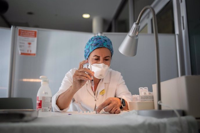 Archivo - Una enfermera prepara la vacuna Pfizer-BioNtech contra el COVID-19 antes de administrársela a un profesional sanitario en el Hospital de la Santa Creu i Sant Pau de Barcelona.