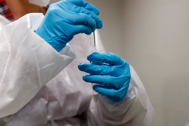 Un trabajadora sanitaria sostiene un test de antígenos.