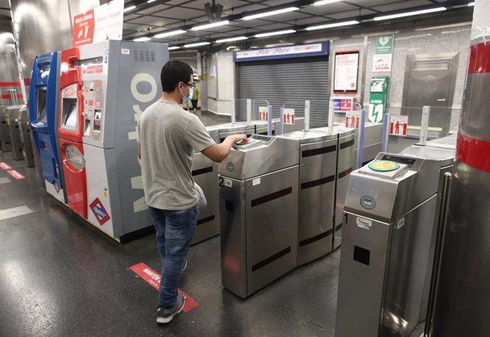 Archivo - Un joven pasa su billete en el torno del Metro Plaza de España, en Madrid (España).