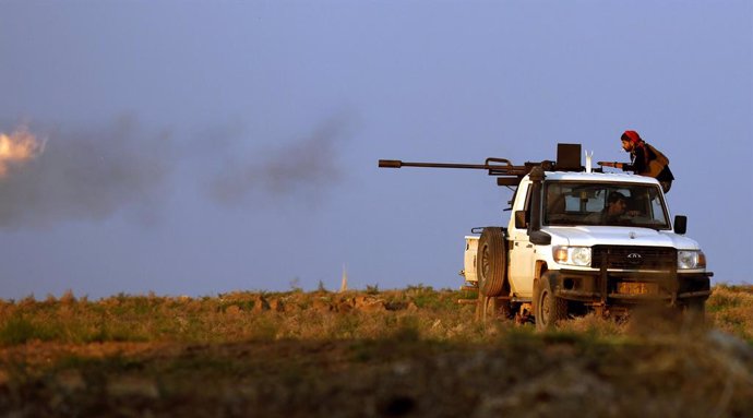 Archivo - 02 November 2019, Syria, Tall Tamr: A fighter of the People's Protection Units (YPG) Kurdish group fires his truck-mounted machine gun during clashes with Turkish forces. Photo: Carol Guzy/ZUMA Wire/dpa