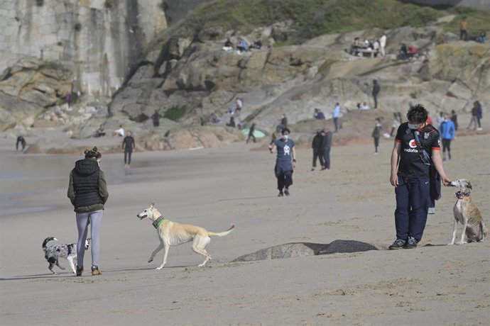 Archivo - Varias personas disfrutan de un día de primavera en la playa del Orzán, en A Coruña