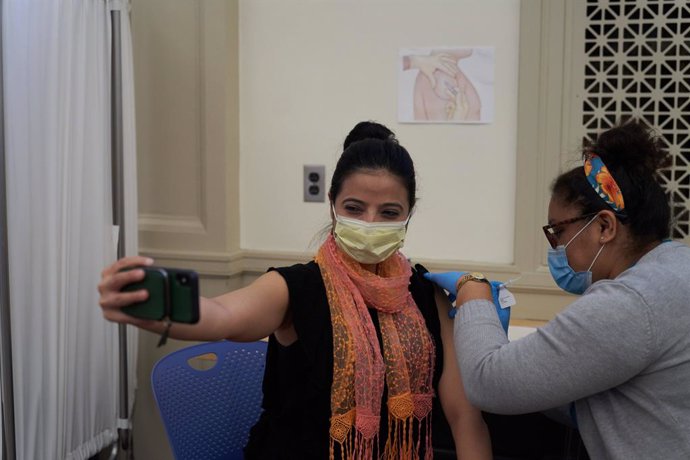 Archivo - 21 December 2020, US, Worcester: A woman takes a selfie as she receives her Pfizer Coronavirus (Covid-19) vaccine at a vaccination centre in UMass Memorial Hospital in Worcester. Photo: Allison Dinner/ZUMA Wire/dpa
