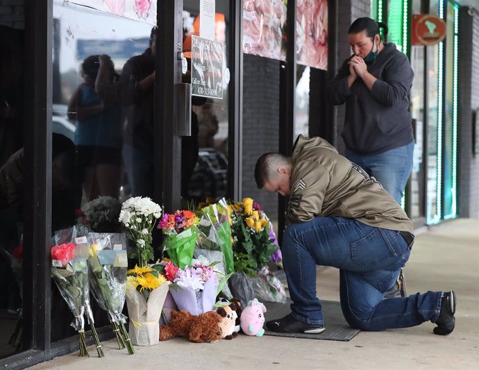 Archivo - 17 March 2021, US, Acworth: March 17, 2021, Acworth, GA, USA: U.S. Army veteran Latrelle Rolling (L), and Jessica Lang, pray after dropping off flowers at Young's Asian Massage in Acworth. Eight people were killed and one injured in shootings 