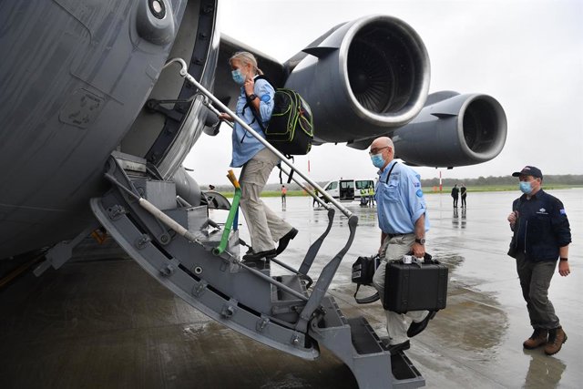 AUSMAT medical team members Angela Jackson (left), Dr Mark Little (centre) and Leigh Cox (right) are seen boarding a C-17A Globemaster at RAAF Base Amberley, west of Brisbane, Tuesday, March 23, 2021. Australia are sending 8,000 doses of its COVID-19 vacc