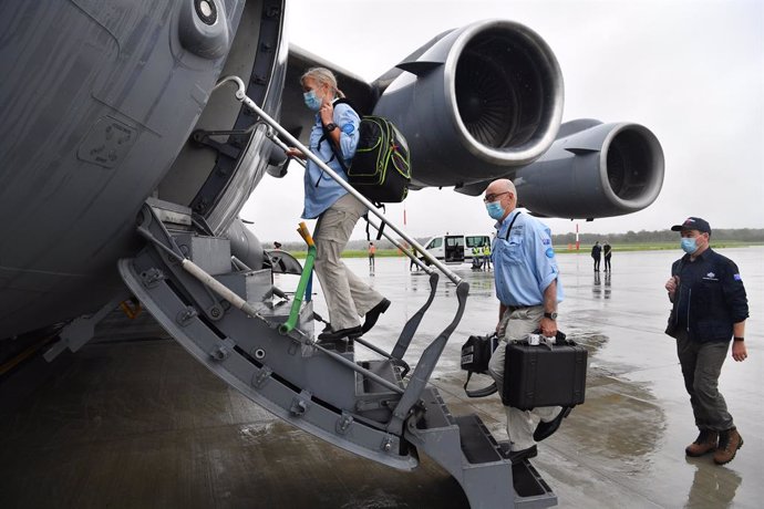 AUSMAT medical team members Angela Jackson (left), Dr Mark Little (centre) and Leigh Cox (right) are seen boarding a C-17A Globemaster at RAAF Base Amberley, west of Brisbane, Tuesday, March 23, 2021. Australia are sending 8,000 doses of its COVID-19 va