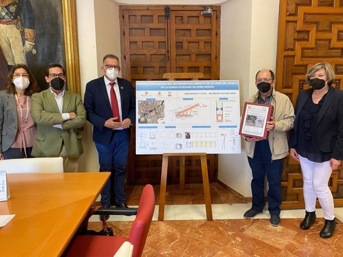 El delegado de Cohesión Territorial de la Diputación de Córdoba, Juan Díaz (tercero por la izda.), entrega al alcalde de Doña Mencíael proyecto de reparación el arroyo de la Cruz del Muelle.