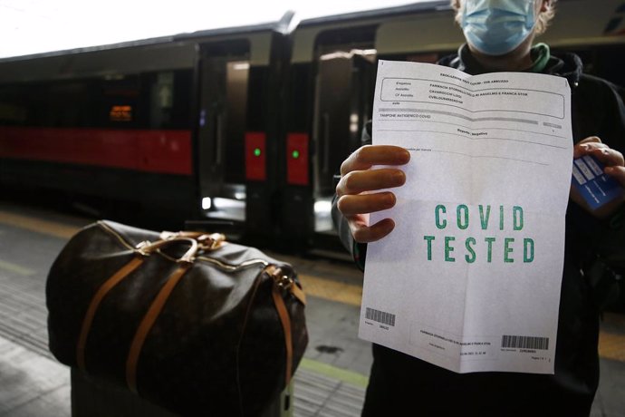 16 April 2021, Italy, Rome: A passenger shows the result of the coronavirus (COVID-19) swab test at Roma Termini Railway station before boarding the newly inaugurated Rome-Milan Trenitalia train, only passengers with negative results of the COVID-19 swa