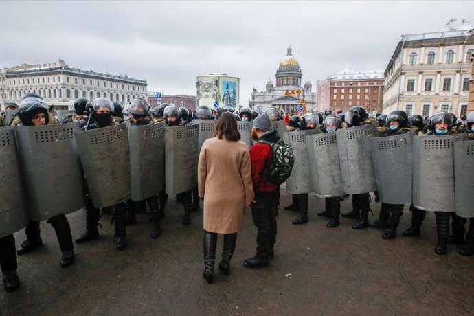 Archivo - 31 January 2021, Russia, Saint Petersburg: A couple stands in front of Russian National guard officers who are blocking a street during a demonstration against the detention of the Russian opposition leader Alexey Navalny. Navalny was immediat