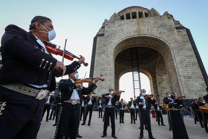 Archivo - 22 November 2020, Mexico, Mexico City: Members of a Mariachi band perform in front of the monument to the Revolution as part of an activity called "#SalvemosAlMarichi" which demands financial support from the government to musicians that have 
