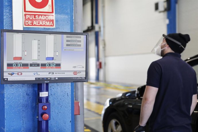 Archivo - Un trabajador observa los niveles de un vehículo en una estación de ITV en Villaverde