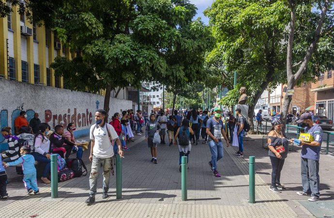 Archivo - Personas con mascarillas en una calle de Caracas