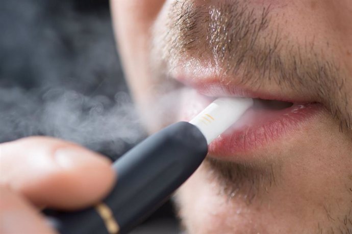 Archivo - FILED - 31 May 2019, Saxony, Dresden: A man smokes with the electronic tobacco heater IQOS (I quit ordinary smoking). China plans to ban electronic cigarette smoking in public places to stop the increase in the use of cigarettes among teenager