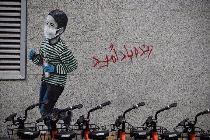 Archivo - Un graffiti que muestra a un niño con mascarilla en la capital de Irán, Teherán. 