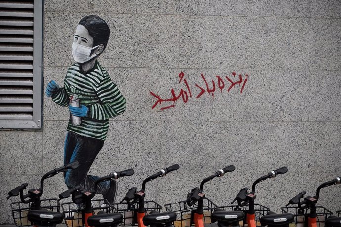 Archivo - 30 April 2020, Iran, Tehran: A graffiti of a young boy wearing a face mask is seen on a wall on a street in Tehran amid the coronavirus pandemic. Photo: Rouzbeh Fouladi/ZUMA Wire/dpa