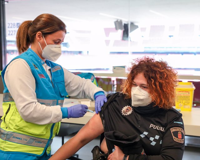 Una sanitaria vacuna a una policía en el punto de vacunación contra el Covid-19 puesto en marcha en el Estadio Wanda Metropolitano el primer día de su funcionamiento