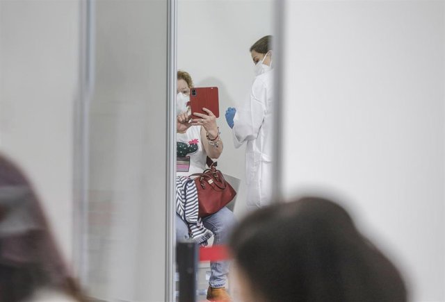 Una mujer se toma un selfie mientras es vacunada en el primer día de la vacunación masiva en la Comunidad Valenciana