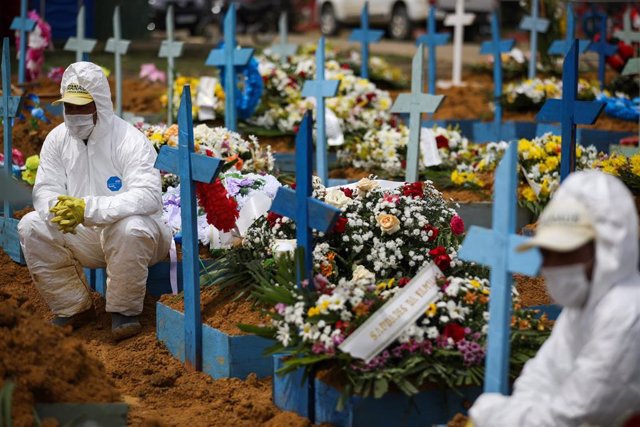 Archivo - Trabajadores de un cementerio con trajes de protección tras enterras a víctimas del coronavirus en Manaos, Brasil.