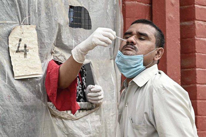 20 April 2021, India, Prayagraj: A health worker collects a swab sample from a man for Coronavirus (Covid-19) PCR test. Photo: Prabhat Kumar Verma/ZUMA Wire/dpa