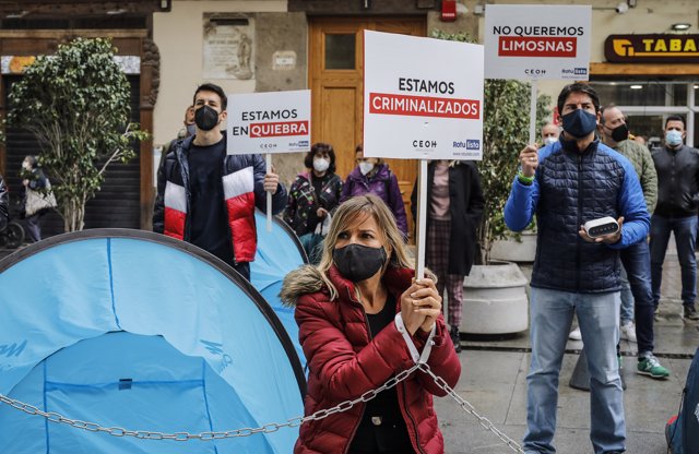 Una trabajadora del ocio nocturno encadenada en frente al Palau de la Generalitat para mostrar "la condena a la que se les está sometiendo sin un plan de rescate económico real que garantice su supervivencia"