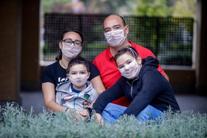 Archivo - Los hermanos Hugo (i) y Álvaro Romero, junto a su madre Elena Álvarez y su padre Francisco Javier Romero, posan frente a cámara con una mascarilla transparente, ideal para personas sordas, en Villaverde (Madrid)